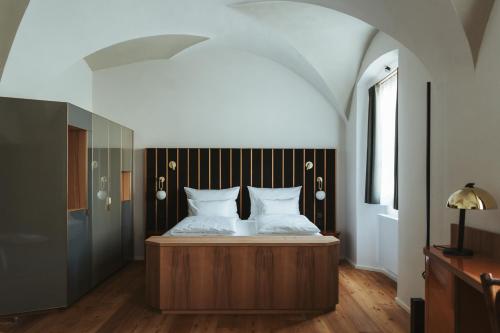 BrixenArthotel Lasserhaus的一间卧室配有一张铺有木地板的床。