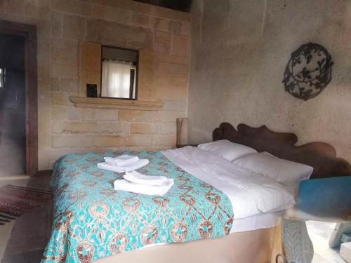 阿瓦诺斯Mozaik Stone Hotel的一间卧室配有带毛巾的床