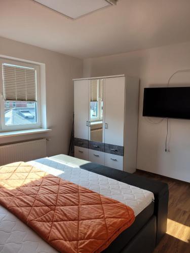 威廉港Schöne einfache Ferienwohnung zwischen Stadt und Meer的一间卧室配有一张床和一台平面电视