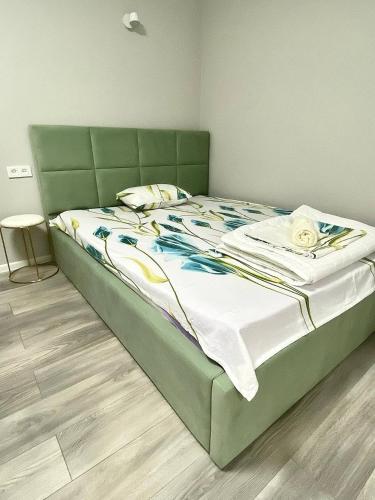 (( Turksib ))Апартаменты аэропорт 1的卧室内的一张带绿色床头板的大床
