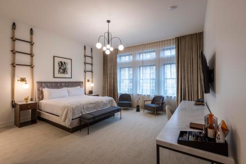 卡温顿Hotel Covington Cincinnati Riverfront的一间卧室设有一张床和一间客厅。