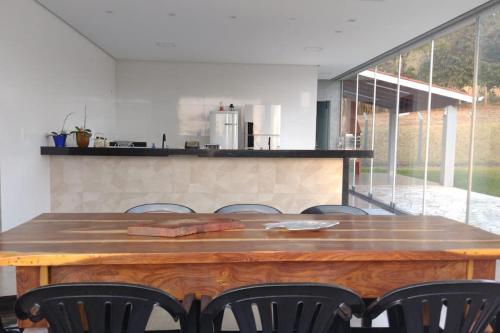 皮乌米Rancho Pôr do Sol的厨房里配有一张大木桌和椅子