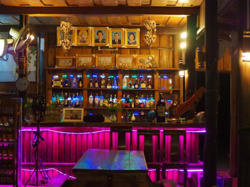 瓜隆岛Coconutbeach Bungalows Party Hostel的一间酒吧,在房间内有紫色的灯光