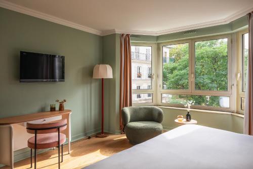 巴黎Royal Garden Champs-Élysées的卧室配有床、椅子和窗户。