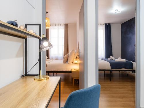 维也纳La Petite Histoire的客房设有两张床和一张带台灯的桌子。