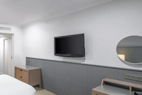 赫尔假日赫尔海滨酒店的一间白色墙壁上配有电视的房间
