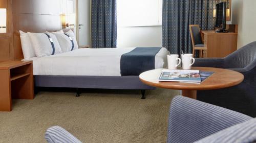 赫尔假日赫尔海滨酒店的酒店客房带一张床、一张桌子和椅子