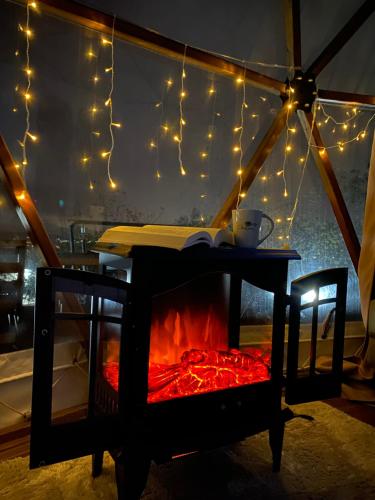 萨潘贾Phalesia Glamping Otel的帐篷内的壁炉、灯和桌子