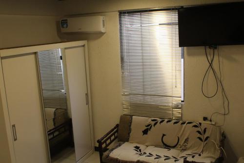 埃斯特城Apartamento 1的小房间设有窗户、沙发和镜子