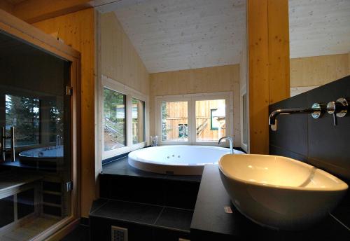 图拉彻霍赫AlpenChalet ZirbenDuft的带浴缸和两个盥洗盆的大浴室