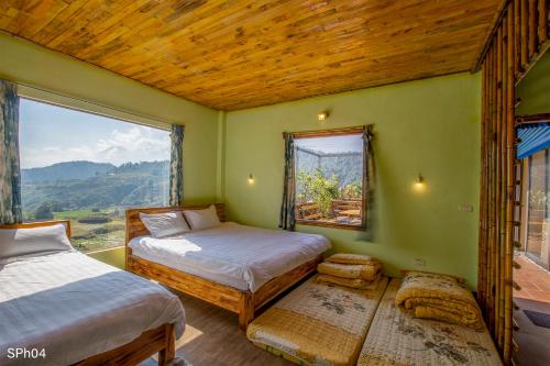 萨帕Stone Paradise Homestay的一间卧室设有两张床和大窗户