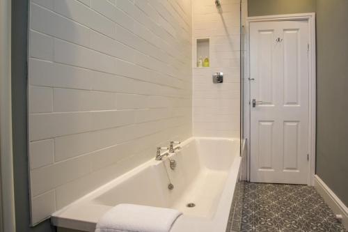 霍伊莱克Fairways View - Spacious Apartment - Sleeps 6 - Lovely Views的白色的浴室设有浴缸和卫生间。