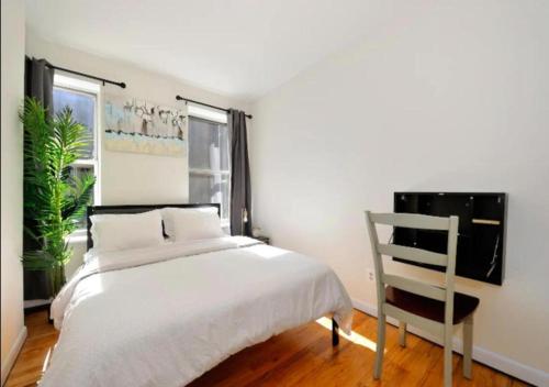 纽约Amazing 2 Bedroom Apartment At UES的卧室配有白色的床和椅子