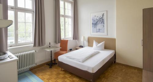 康斯坦茨康斯坦斯公寓酒店的一间卧室设有一张床和两个窗户。