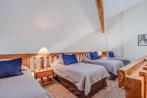 布雷肯里奇Pine Ridge 05F的带3张床和蓝色枕头的客房