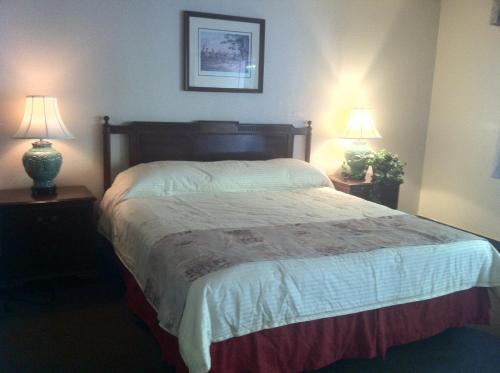 圣何塞Caravelle Inn Extended Stay的一间卧室配有一张大床和两盏灯