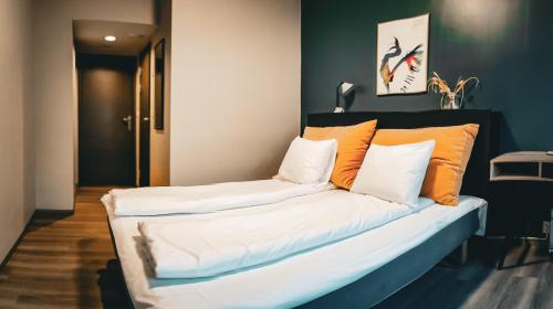莫尔德Hotell Molde的客房内的沙发配有橙色和白色枕头