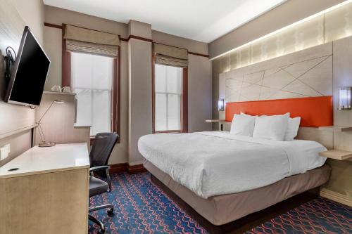 圣安东尼奥阿拉莫/河滨贝斯特韦斯特尊贵历史旅客酒店的酒店客房设有一张大床和一张书桌。