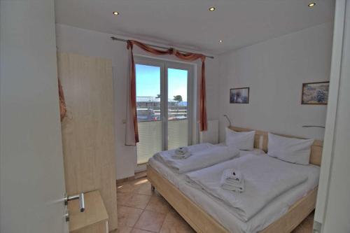 萨斯尼茨Ferienwohnung Kutterfisch direkt im Stadthafen的一间卧室设有一张大床和一个窗户。