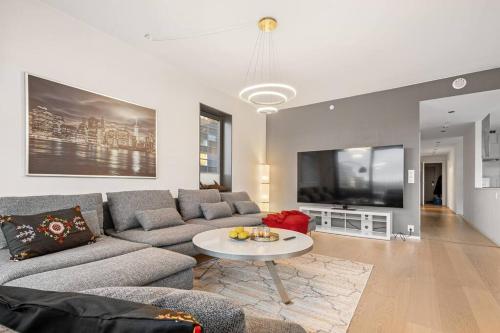 奥斯陆Modern 3bed room sea view apartment @ Oslo Barcode的客厅配有沙发和桌子