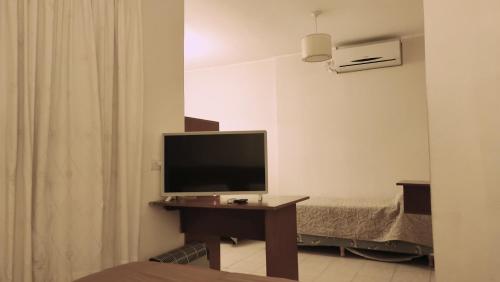 米娜克拉韦罗Coronado Hotel的一张桌子上配有电视的房间,一张床位