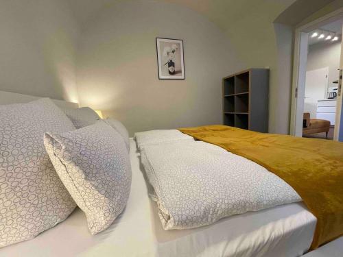 皮尔纳Design-Suite Am Markt的一间卧室配有带白色床单和枕头的床。