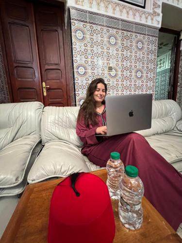 拉巴特Dar Yassine的坐在沙发上的手提电脑的女人
