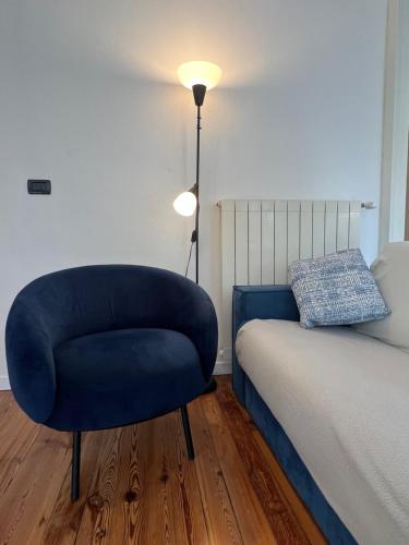 奥梅尼亚Canottieri home的卧室配有蓝色椅子,位于床边