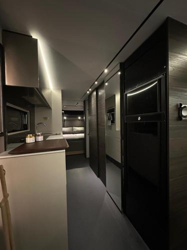 罗瓦涅米Santa`s luxury trailer的厨房配有柜台、水槽和冰箱。