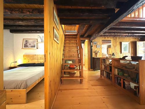 拉加玛艾佩德拉Molí de Dalt的一间卧室设有一张床和木制楼梯。