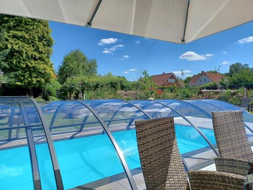 LageExklusive Dorfpension mit Pool und Sauna的一个带椅子和玻璃屋顶的游泳池