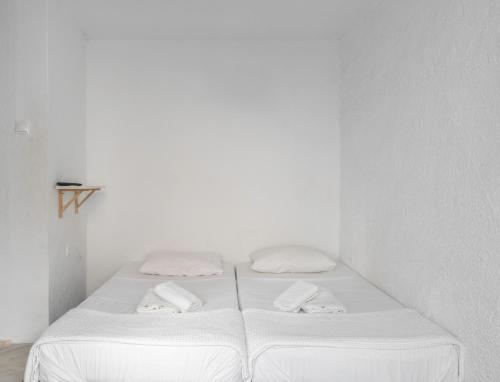 雅典Detached house 1km from Acropolis Filopappou的白色卧室配有两张带毛巾的床