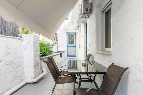 雅典Detached house 1km from Acropolis Filopappou的阳台配有一张桌子和椅子,阳台设有蓝色的门