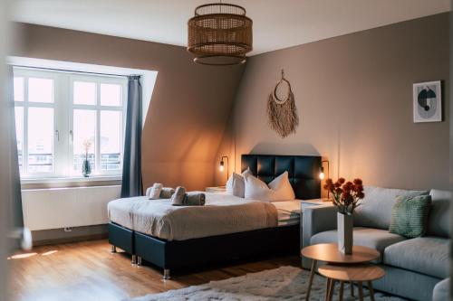 莱比锡Luga Homes - Stadthaus的一间卧室配有一张床和一张沙发