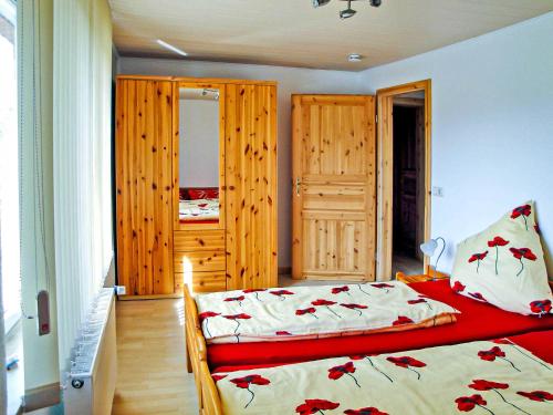 马尔肖Ferienwohnungen Fleesensee的一间卧室配有一张床和木制橱柜