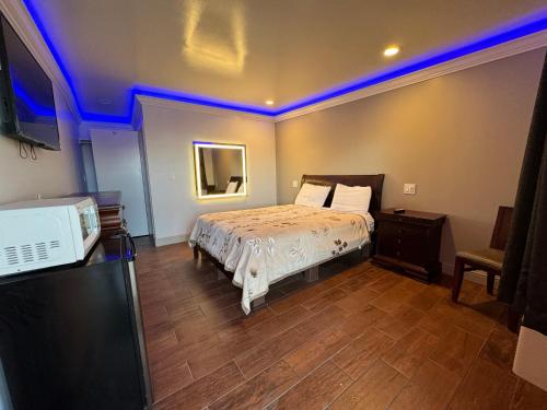 GreenfieldTravel Inn的一间卧室配有一张蓝色灯床