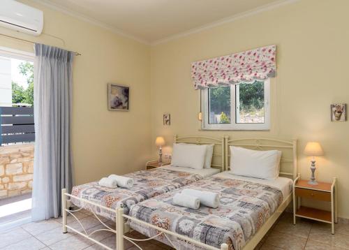 斯加雷塔Amarlia Villa的一间卧室配有带两个枕头的床和窗户