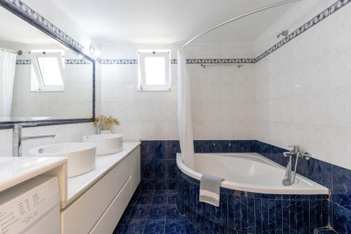 斯加雷塔Amarlia Villa的浴室配有两个盥洗盆和浴缸。