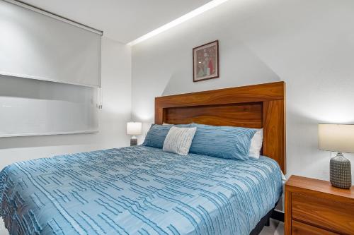 巴亚尔塔港V Golf 601的一间卧室配有一张带木制床头板的床和两盏灯。