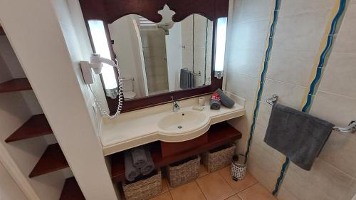 圣吕斯Les Frangipaniers的一间带水槽和镜子的浴室