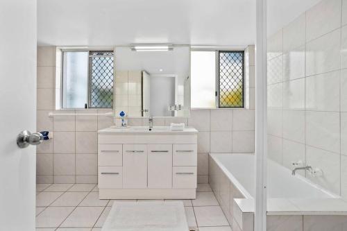 黄金海岸Bilinga Beach House的白色的浴室设有水槽、浴缸和镜子