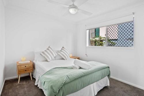 黄金海岸Bilinga Beach House的白色的卧室设有床和窗户