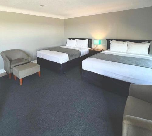 伯灵顿City View Inn的酒店客房,配有两张床和椅子