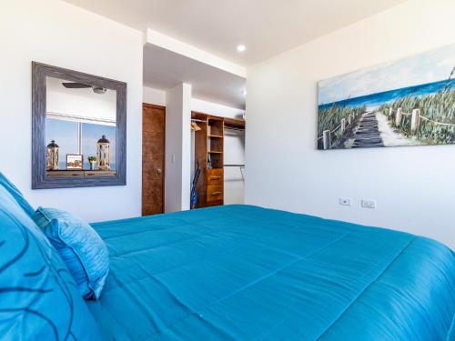 提华纳Cielomar的卧室配有蓝色的床和墙上的绘画作品