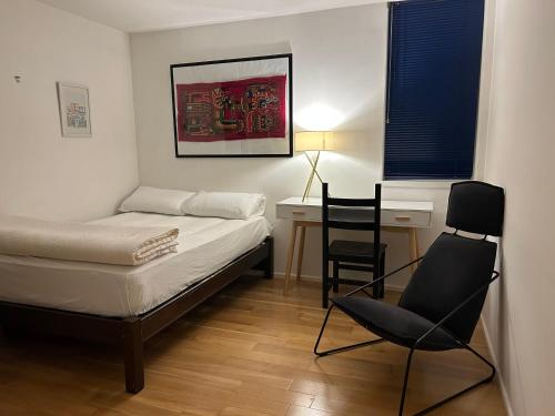 伦敦No-taking-reservations的一间卧室配有一张床、一张桌子和一把椅子