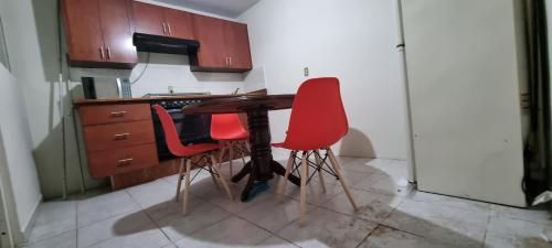 坦皮科Departamento Planta Baja para 6的厨房配有木桌和2把红色椅子