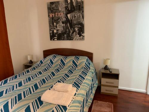圣地亚哥A 100 pasos de la Alameda 45910的卧室内的一张带蓝色和白色条纹棉被的床