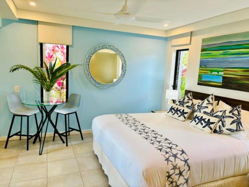 道格拉斯港Paradise Escape - Poolside Ground Floor - Sea Temple Resort and Spa的蓝色卧室,配有床和桌子