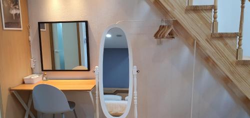 首尔JSM Studio Hongdae的一间带梳妆台和镜子的浴室以及一张书桌