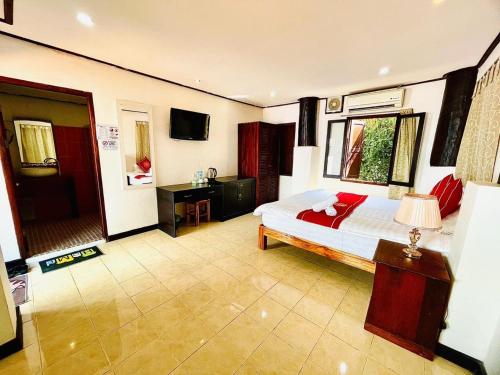 琅勃拉邦Vieng Savanh II Hotel的一间卧室配有一张床和一台电视